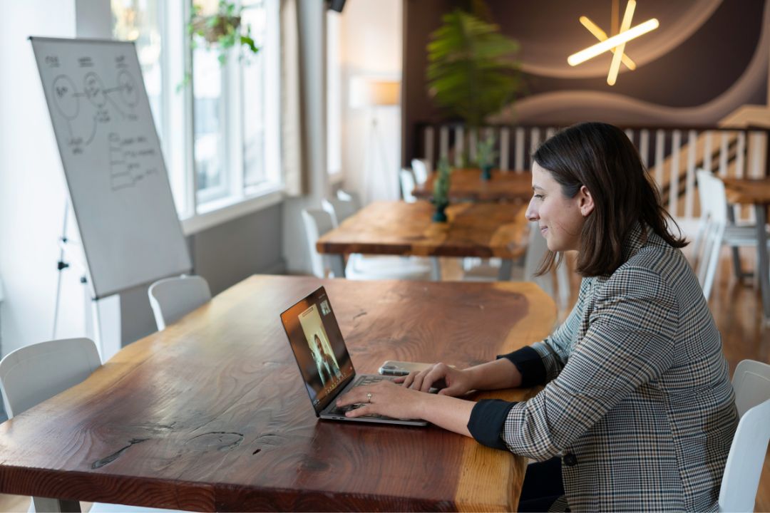 Eine Frau sitzt vor einem Laptop und nimmt an einem hybriden Warm-Up teil